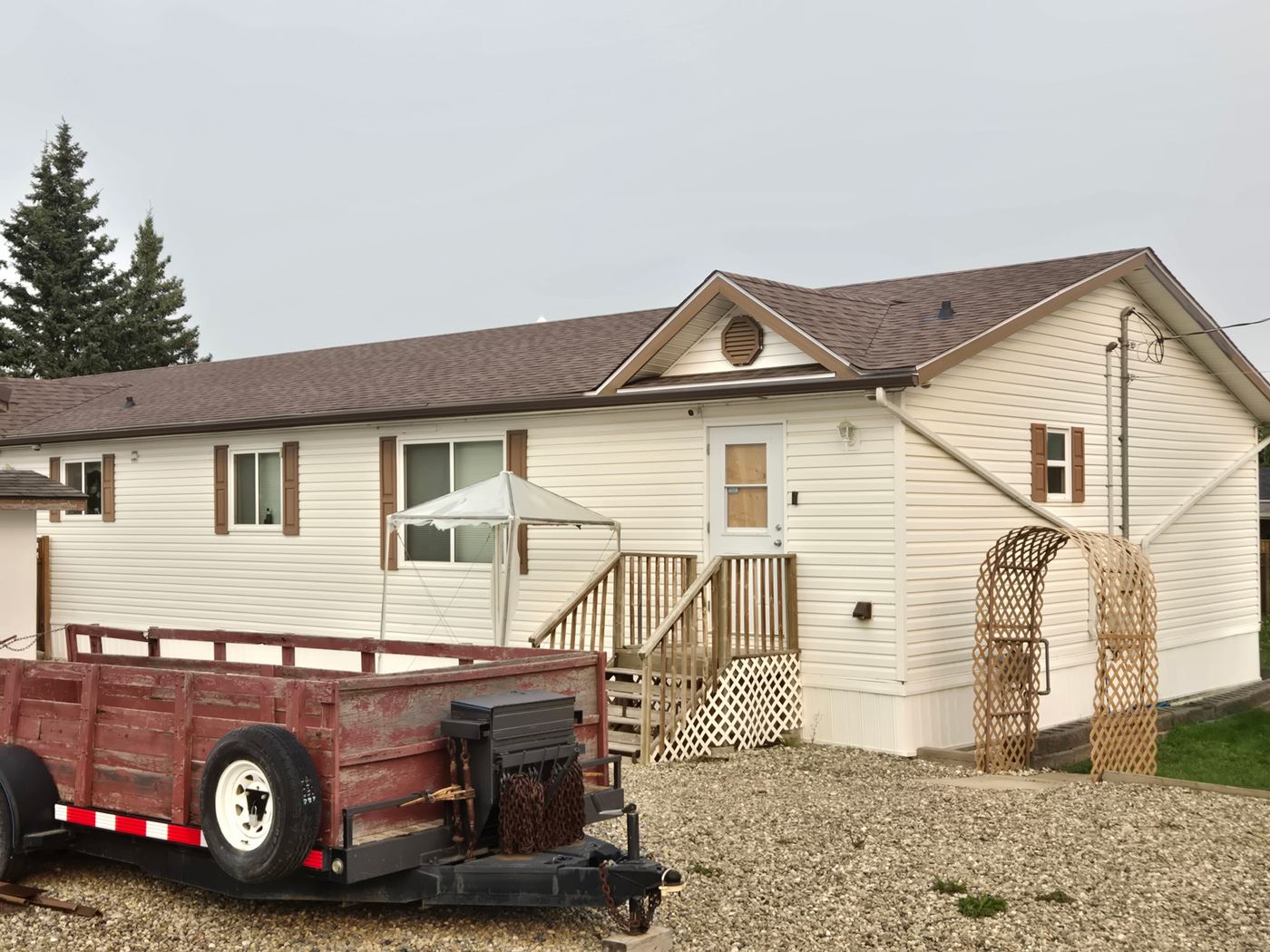 Completed roof and eavestrough line seen from the ground, Peace Region · Sunnybrook Roofing
